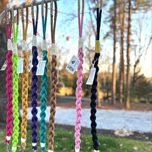 A collection of colorful dog leashes hanging on display, with tags attached to each.
