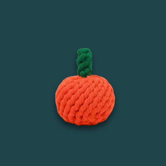 Handmade orange rope dog toy with a green handle.