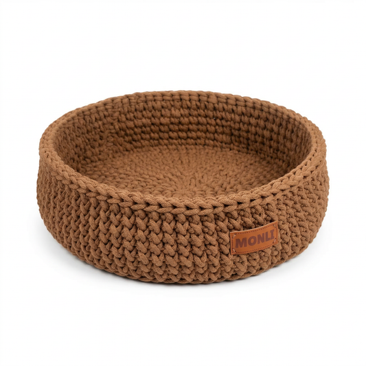 Brown knitted pet bed with a brand label on a white background