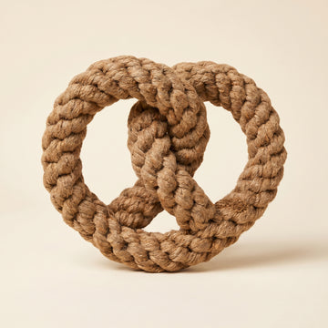 Brown braided rope toy on a beige background