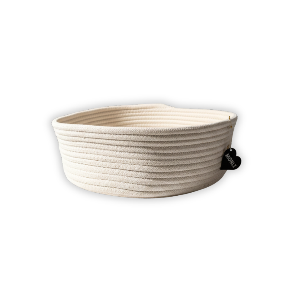 Beige woven basket with a black tag on a white background