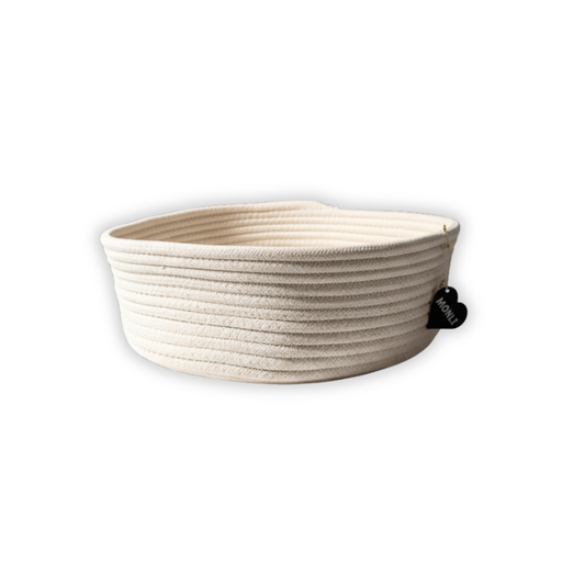 Beige woven basket with a black tag on a white background