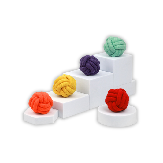 Colorful knot toys on a white geometric stand with a white background