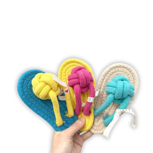 Colorful knotted sandles held by a hand on a white background