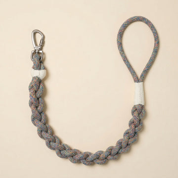 Braided rope dog leash with metal clip on beige background