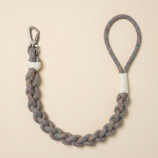 Braided rope dog leash with metal clip on beige background