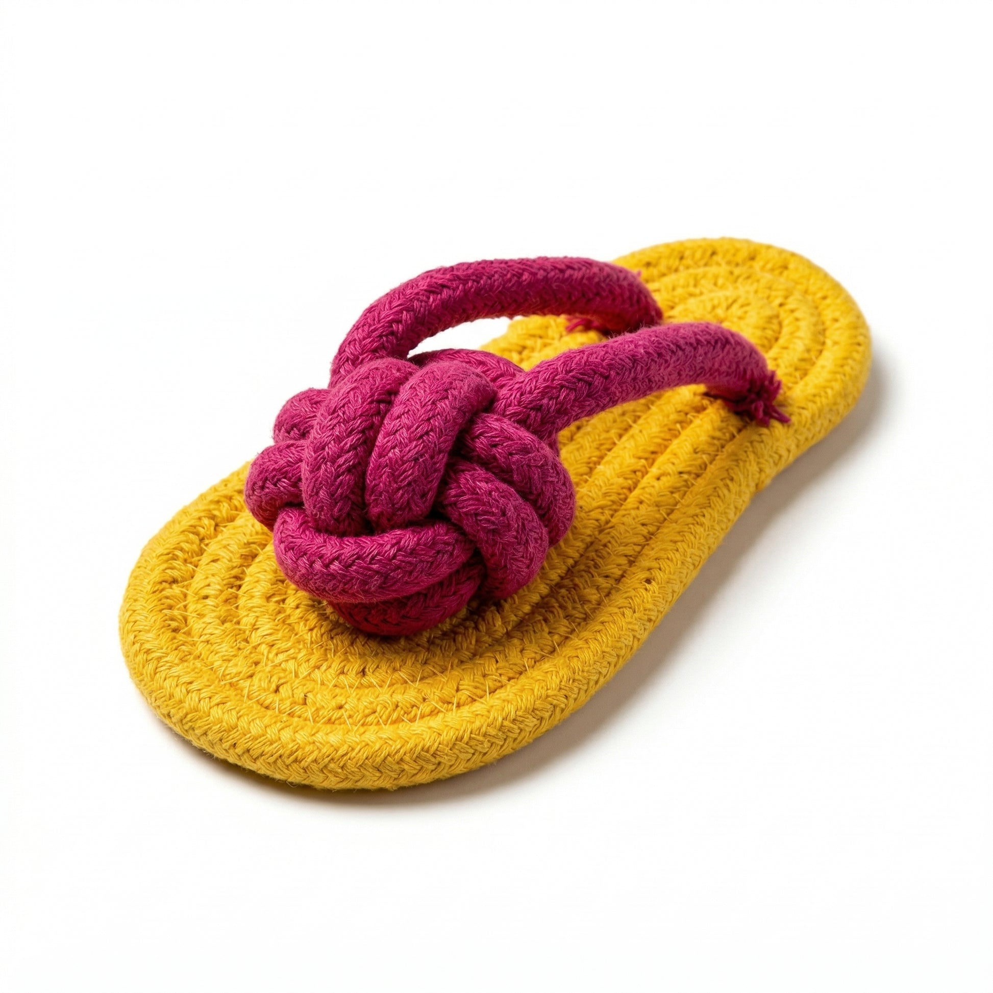 Yellow sandal with pink knotted strap on a white background