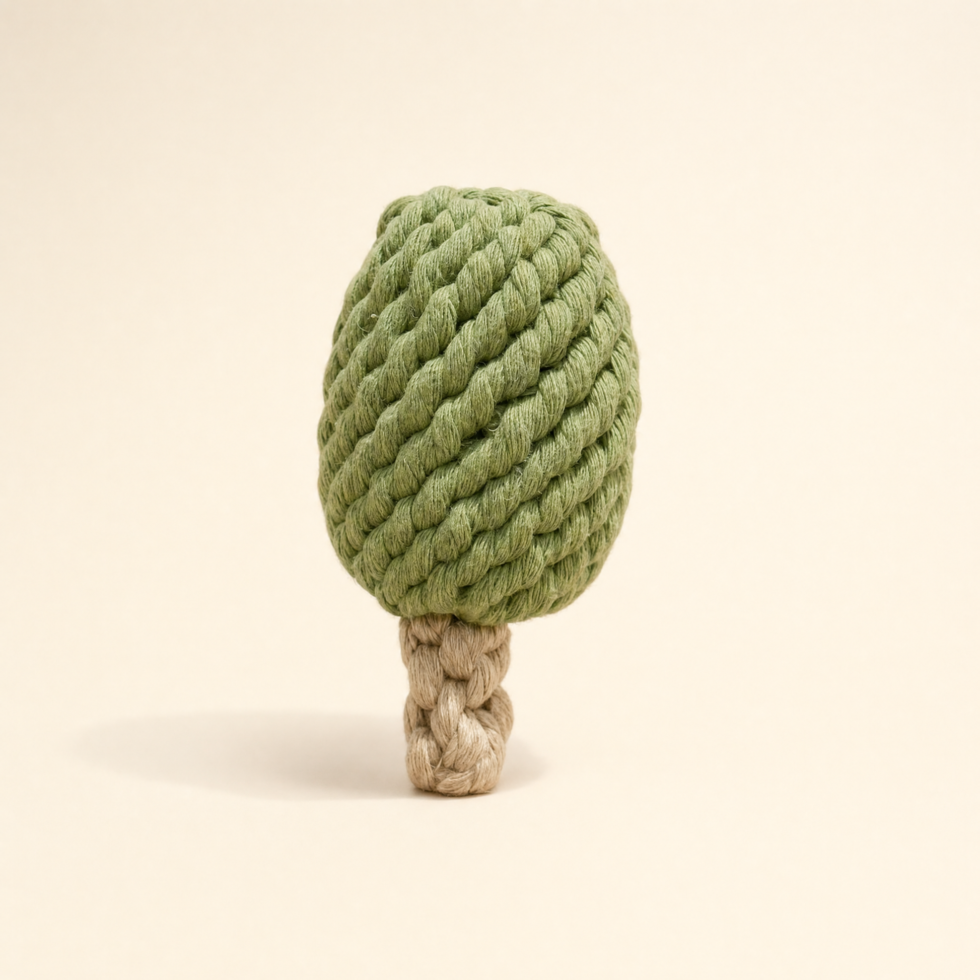 A rope dog toy shaped like a matcha ice cream bar, featuring a textured sage green burlap-like crown and a natural tan rope trunk, set against a solid cream background.