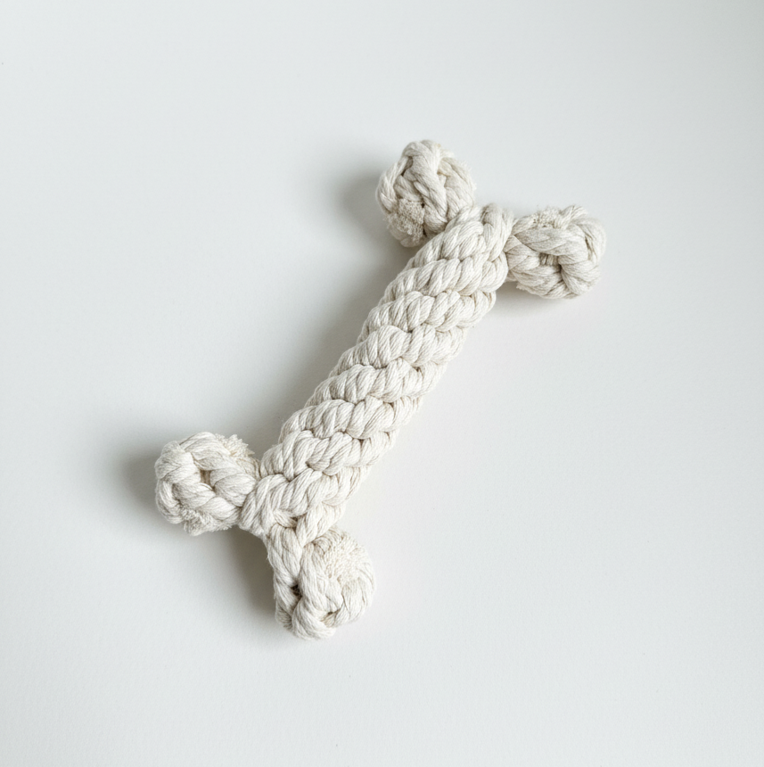 White knotted rope toy on a light gray background