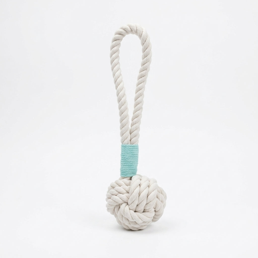 White rope toy with a knotted ball and a turquoise band on a white background